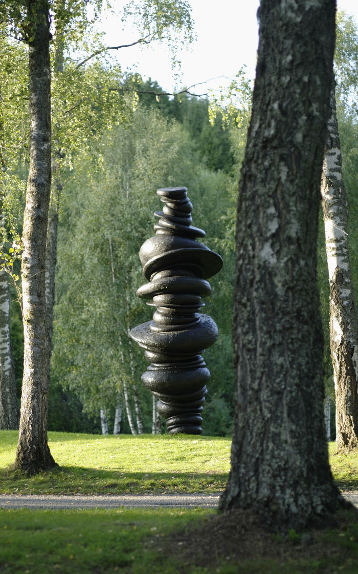 Skulptur, svart, sirkler plassert oppå hverandre, grønn natur